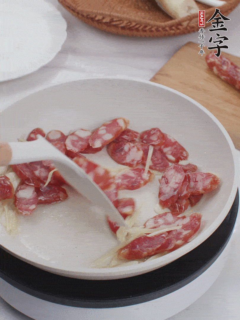 油溫3成熱時，下姜絲、蒜片、香腸炒出油脂。