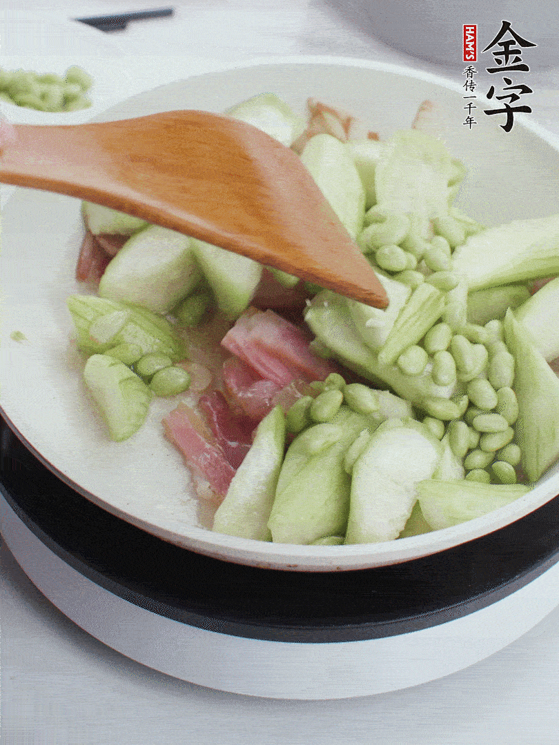 依次下絲瓜、青豆翻炒，炒至絲瓜打蔫縮小。