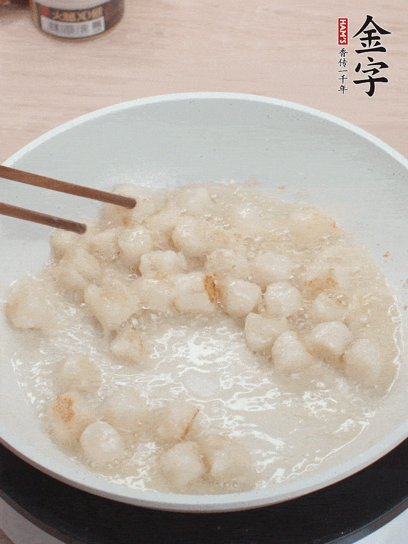 油溫4成熱，鮮貝蘸干淀粉下鍋煎，一面微黃后翻面。