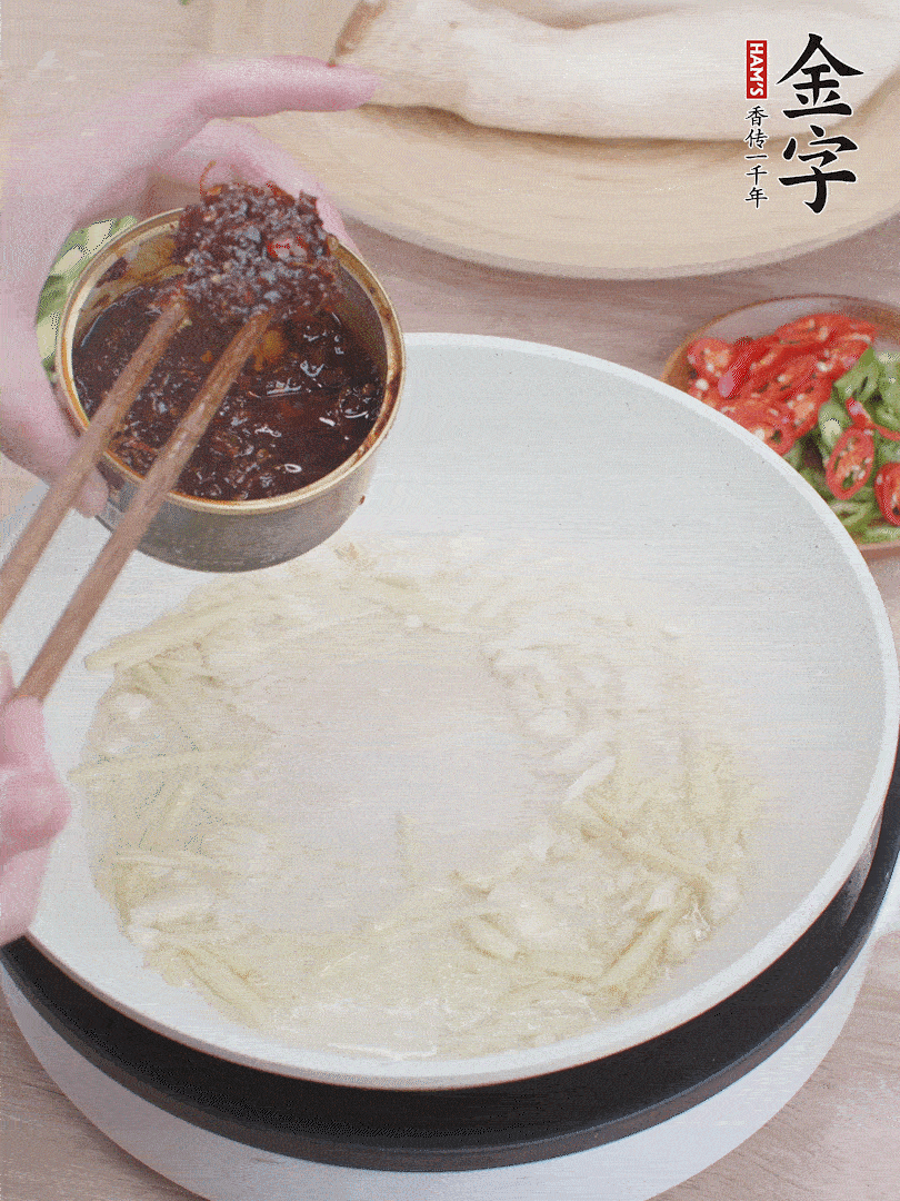 起鍋熱油，姜蒜、金字火腿干貝醬煸香。