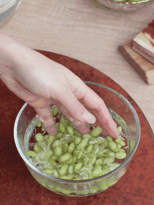 青豆剝殼，搓去外衣。