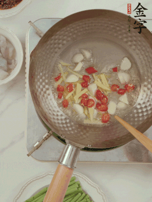 油7成熱時(shí)，下大蒜粒、姜絲、小米辣煸香。