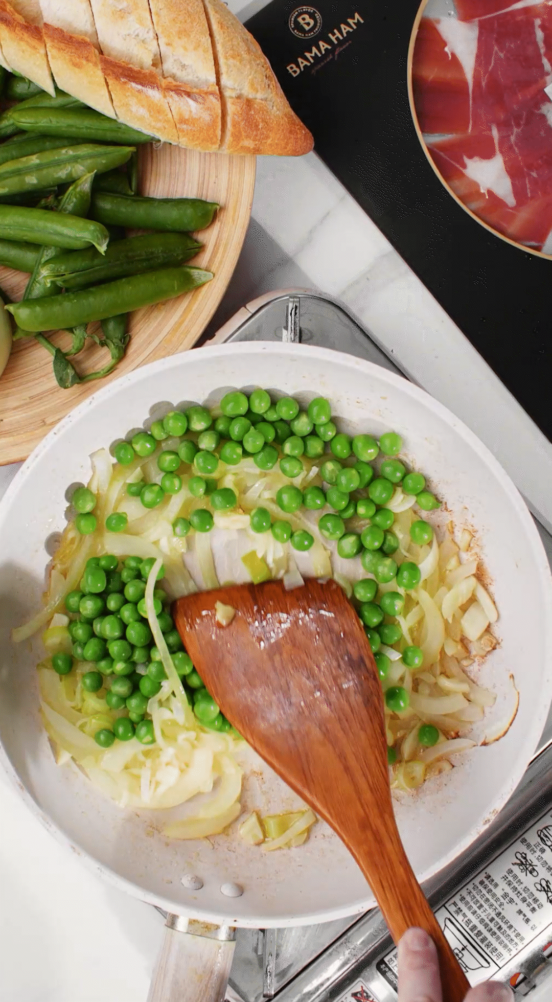 鍋中放入黃油融化，加入洋蔥絲、大蔥蔥白絲、蒜末翻炒變軟出香味。加入剛剛汆燙冰鎮(zhèn)后的豌豆，取出一點點待會擺盤裝飾用。加一點鹽 (和黑胡椒) 調(diào)味。